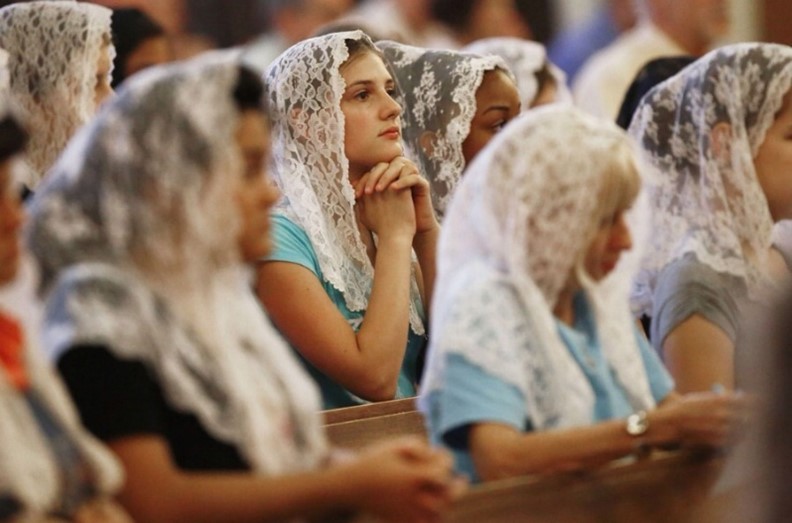 Veiled women in pews praying together